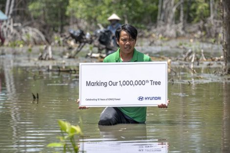homem a segurar um cheque de 1 milhão de árvores plantadas.